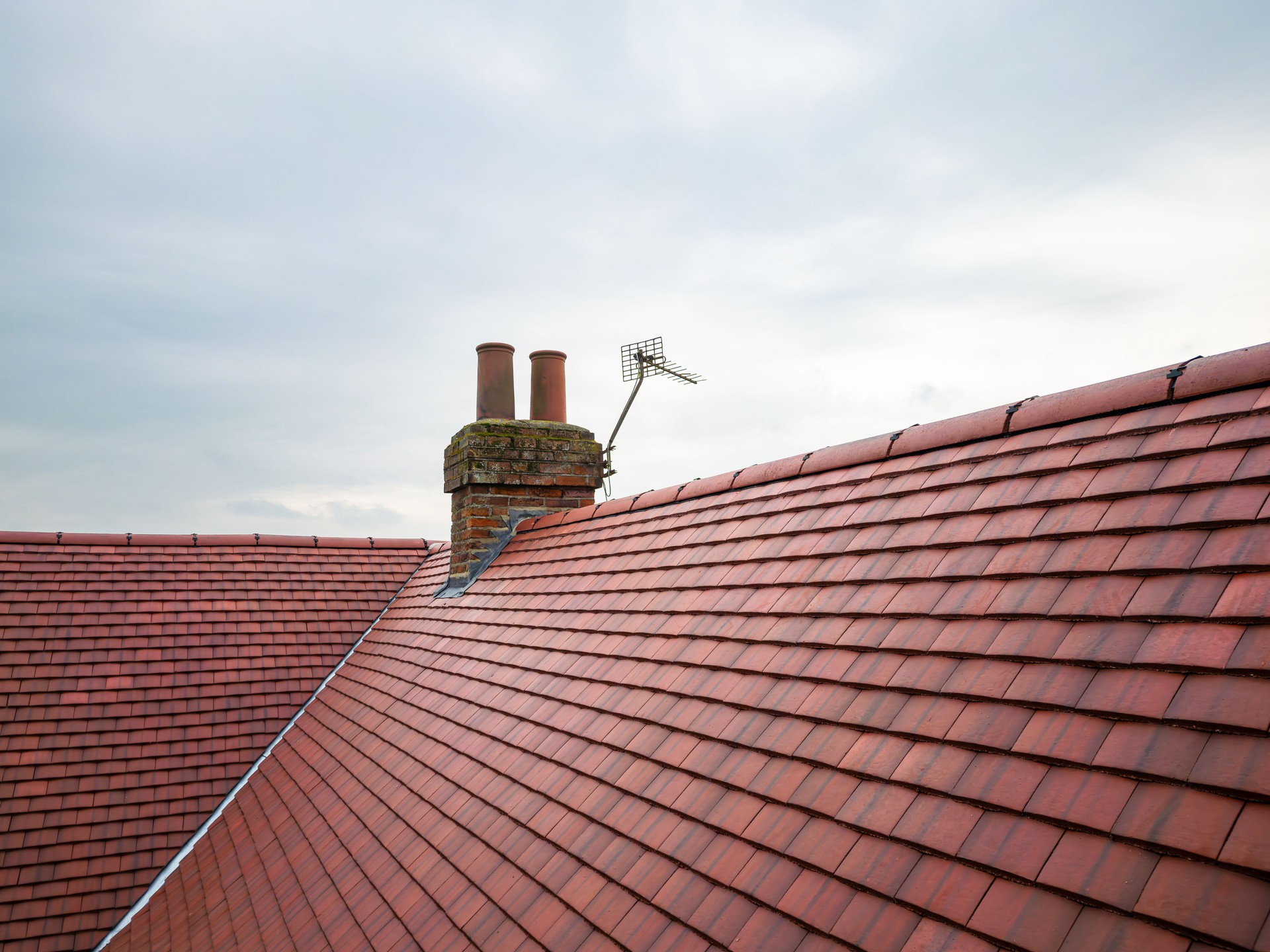 Inspection drone view of a newly installed ceramic roof on an old English farmhouse. Inspection drone view of a newly installed ceramic roof on an old English farmhouse.